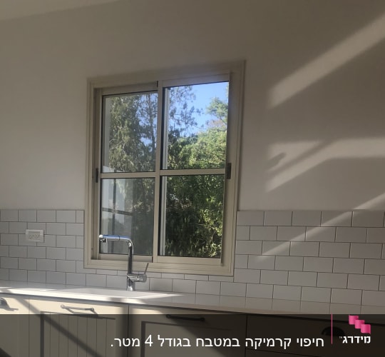 כיור וברז במטבח עם אריחי קיר לבנים